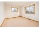 Bedroom featuring neutral carpet, two windows bringing in ample natural light and baseboard trim at 8895 Morton Rd, Niwot, CO 80503