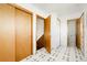 Hallway with patterned tile flooring, multiple doors, and access to a staircase at 8895 Morton Rd, Niwot, CO 80503