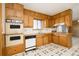 Full kitchen with wood cabinets, double oven, and white appliances set in a cozy design at 8895 Morton Rd, Niwot, CO 80503