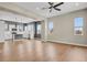 Bright, open-concept living room with modern decor and hardwood floors connected to the modern kitchen and a ceiling fan at 7870 W 43Rd Pl, Wheat Ridge, CO 80033