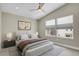 Main bedroom featuring a ceiling fan, art, and two windows with a view of the neighborhood at 7870 W 43Rd Pl, Wheat Ridge, CO 80033