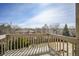 A wood-plank balcony featuring wood railings with views of mature trees and nearby rooftops at 18438 E Berry Dr, Centennial, CO 80015