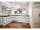 Modern bathroom featuring dual sinks, granite countertops, and stylish wood-look flooring at 18438 E Berry Dr, Centennial, CO 80015