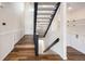 Staircase with hardwood floors, black railing, leading up to a second-floor landing at 18438 E Berry Dr, Centennial, CO 80015