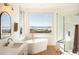 Bright bathroom featuring a soaking tub under a large window with scenic mountain views and a glass-enclosed shower at 4899 N Mesa Dr, Castle Rock, CO 80108