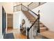 Spacious entryway with wood floors and a staircase featuring a decorative black iron railing at 4899 N Mesa Dr, Castle Rock, CO 80108