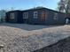 Beautiful exterior view of home with dark siding and gravel landscaping with bright white framed windows at 1285 Roslyn St, Denver, CO 80220