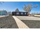 Inviting home exterior with dark siding, gravel landscaping, and a quaint walkway at 1285 Roslyn St, Denver, CO 80220