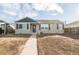 Tan house with dark gray shutters, a dark gray door, and a walkway at 1716 Moline St, Aurora, CO 80010