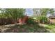 View of the backyard featuring a shed, mature trees, and natural foliage at 8389 Benton Way, Arvada, CO 80003