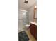 Bathroom with a glass-enclosed shower and a cherry wood vanity with double sinks at 8389 Benton Way, Arvada, CO 80003