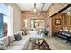 Bright living room with brick accent wall, comfortable sectional sofa, and an open view to the dining space at 2500 Walnut St # 201, Denver, CO 80205