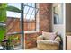 Inviting living space featuring exposed brick, a comfortable armchair, and large windows for plenty of natural light at 2500 Walnut St # 201, Denver, CO 80205