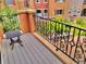 Private balcony with a table and wrought iron railing with lush landscaping and colorful building backdrop at 9238 Viaggio Way, Highlands Ranch, CO 80126