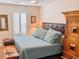 Comfortable bedroom features large bed, wood floors, and shuttered window at 9238 Viaggio Way, Highlands Ranch, CO 80126