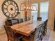 Dining room with a large wood table, seating for eight, unique light fixture, and a decorative wall clock at 9238 Viaggio Way, Highlands Ranch, CO 80126