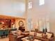 Spacious living room with high ceilings, a leather seating arrangement, and an open floor plan to kitchen at 9238 Viaggio Way, Highlands Ranch, CO 80126