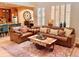 Bright living room featuring large windows, leather sofas, an unique coffee table and an open connection to the kitchen at 9238 Viaggio Way, Highlands Ranch, CO 80126