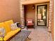 Cozy outdoor patio with comfortable seating, including a yellow sofa, and a peaceful ambiance with stone columns at 9238 Viaggio Way, Highlands Ranch, CO 80126