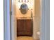 Charming powder room with wood wainscoting, decorative mirror, granite countertop, and neutral color palette at 9238 Viaggio Way, Highlands Ranch, CO 80126