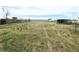 Expansive grassy backyard with room to roam, framed by a few trees and utility sheds at 437 S Fetzer St, Byers, CO 80103