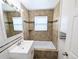 This bathroom has neutral tile, a modern vanity, bathtub and integrated shower head at 437 S Fetzer St, Byers, CO 80103