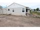 Side view of a home exterior with a gravel driveway and a detached garage at 437 S Fetzer St, Byers, CO 80103