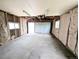 Unfinished garage with exposed insulation, concrete floor, and a white garage door at 437 S Fetzer St, Byers, CO 80103
