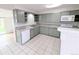 Traditional kitchen boasts light gray cabinets, white appliances, and ample counter space at 437 S Fetzer St, Byers, CO 80103