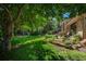 Lush backyard featuring a stone patio, mature trees, and well-maintained lawn at 5063 E Otero Cir, Centennial, CO 80122