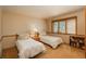 Bedroom featuring two twin beds, a small bedside table and natural light from a window at 5063 E Otero Cir, Centennial, CO 80122