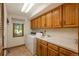 Bright laundry room features a washer, dryer, sink, white countertop, and wooden cabinets at 5063 E Otero Cir, Centennial, CO 80122