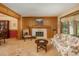 Cozy living room with a wood-paneled accent wall, fireplace, and floral sofa at 5063 E Otero Cir, Centennial, CO 80122