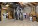 Unfinished basement with concrete floor, exposed pipes, hot water heater and boxes for storage at 10183 Grove Loop # D, Westminster, CO 80031