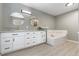 Bright bathroom with dual round mirrors, quartz counters and a tile-surround soaking tub at 10183 Grove Loop # D, Westminster, CO 80031