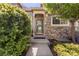 Inviting front entrance with a stone facade, well-manicured bushes, and an overhead door awning at 10183 Grove Loop # D, Westminster, CO 80031