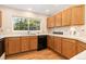 Bright kitchen with oak cabinetry, a large window, and modern appliances at 10183 Grove Loop # D, Westminster, CO 80031