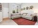 Open living room with tall windows, neutral-toned sectional sofa, and stylish wall decor at 10183 Grove Loop # D, Westminster, CO 80031