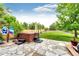 Backyard featuring a hot tub, a patio, and lush greenery, offering a serene outdoor experience at 12000 Horseshoe Ln, Parker, CO 80138