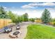 Charming backyard oasis with a stone fire pit, inviting seating, and lush landscaping at 12000 Horseshoe Ln, Parker, CO 80138