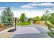 Spacious backyard with a basketball court, lush lawn, patio, and privacy fence at 12000 Horseshoe Ln, Parker, CO 80138