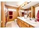 Bright bathroom features a double vanity, a large mirror, and a shower with colorful curtains at 12000 Horseshoe Ln, Parker, CO 80138