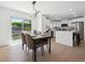 Bright dining area with backyard access, modern light fixture, and an adjacent kitchen at 3247 S Newland St, Denver, CO 80227