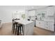 Bright kitchen features waterfall island, sleek white cabinetry, gold hardware, and stainless steel appliances at 3247 S Newland St, Denver, CO 80227