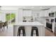 Bright kitchen boasts island with seating, stainless appliances, white cabinets and flows into dining area at 3247 S Newland St, Denver, CO 80227