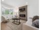 Bright living room featuring a decorative fireplace wall, large bay window, and hardwood floors at 3247 S Newland St, Denver, CO 80227