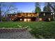 Backyard with large two-story deck and green lawn with retaining wall at 5290 Nassau E Cir, Cherry Hills Village, CO 80113