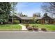 Charming single-story home with lush lawn, mature trees, and inviting walkway leading to the front door at 5290 Nassau E Cir, Cherry Hills Village, CO 80113