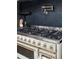 Close up of gas stovetop with gold accents and black backsplash at 5290 Nassau E Cir, Cherry Hills Village, CO 80113