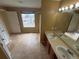 Bright bathroom featuring double sinks, tile floors, and natural light from the window at 11304 Niagara St, Thornton, CO 80233